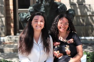 two women siting side by side smiling