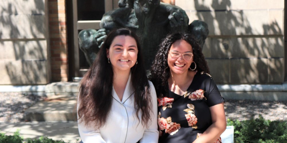 two women siting side by side smiling