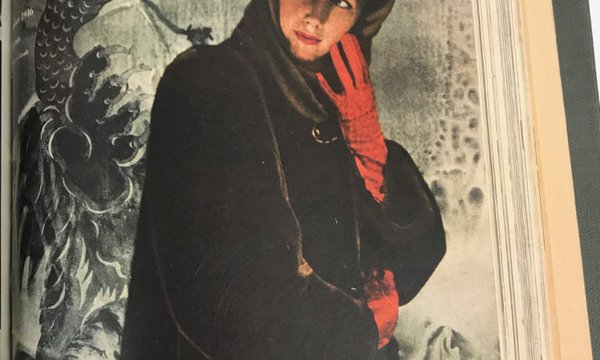 Woman in a hooded black coat wearing red gloves