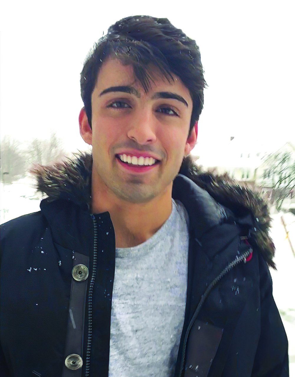 young man wearing dark parka outside