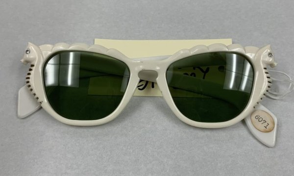 Pair of white sunglasses with seahorses on the sides of the lenses.