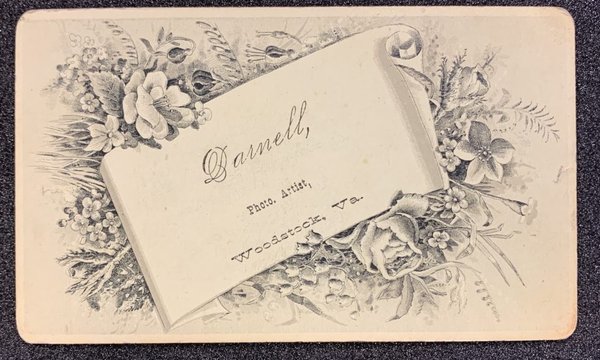 White scroll surrounded by flower illustrations.