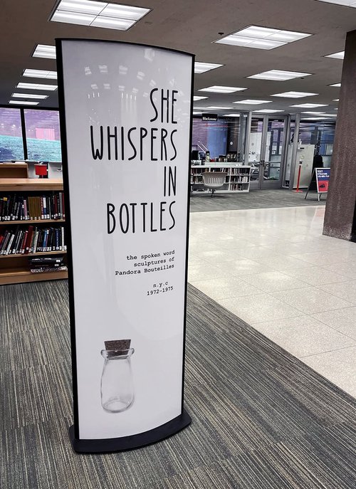 poster with words "She whispers in bottles" and small glass bottle at bottom