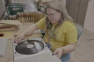 person working with lacquer disc at work table