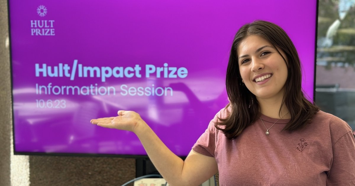 woman pointing to screen that reads "Hult Impact Prize"