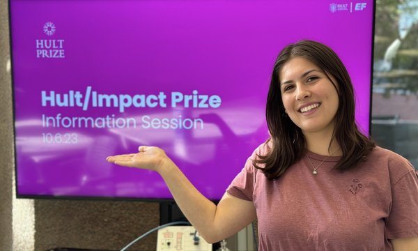 woman pointing to screen that reads "Hult Impact Prize"