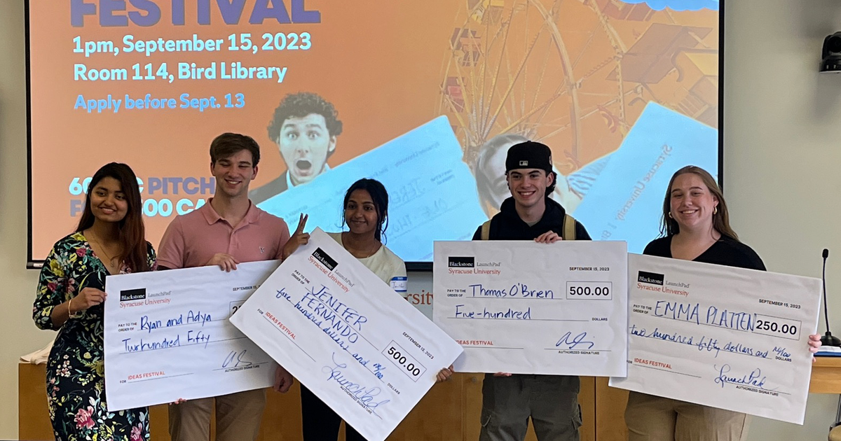 five students holding oversize checks.
