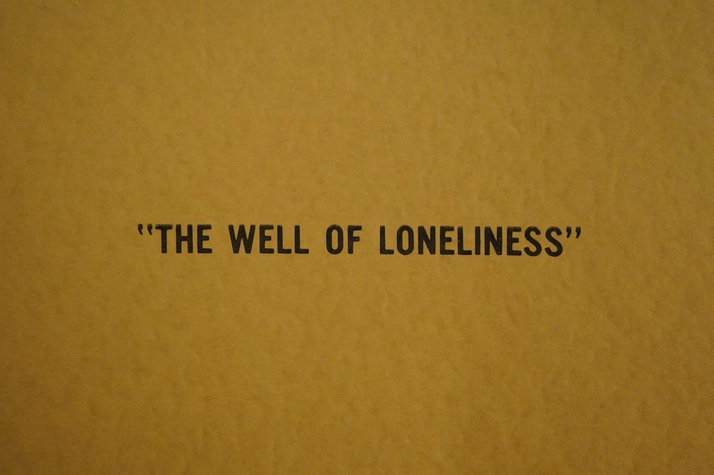 Yellow background with words "Well of Loneliness" in black