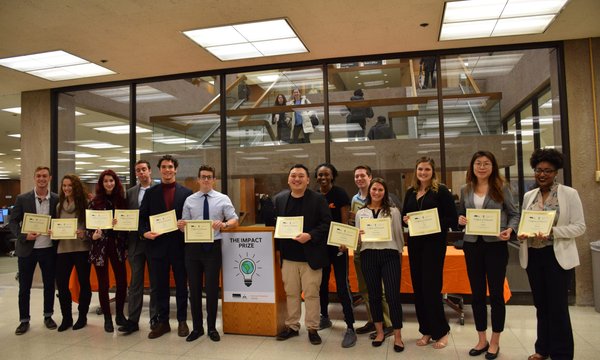 row of students standing with oversized checks in their hands