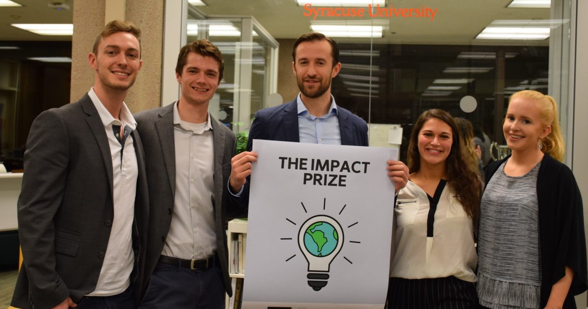 group standing with sign that reads Impact Prize