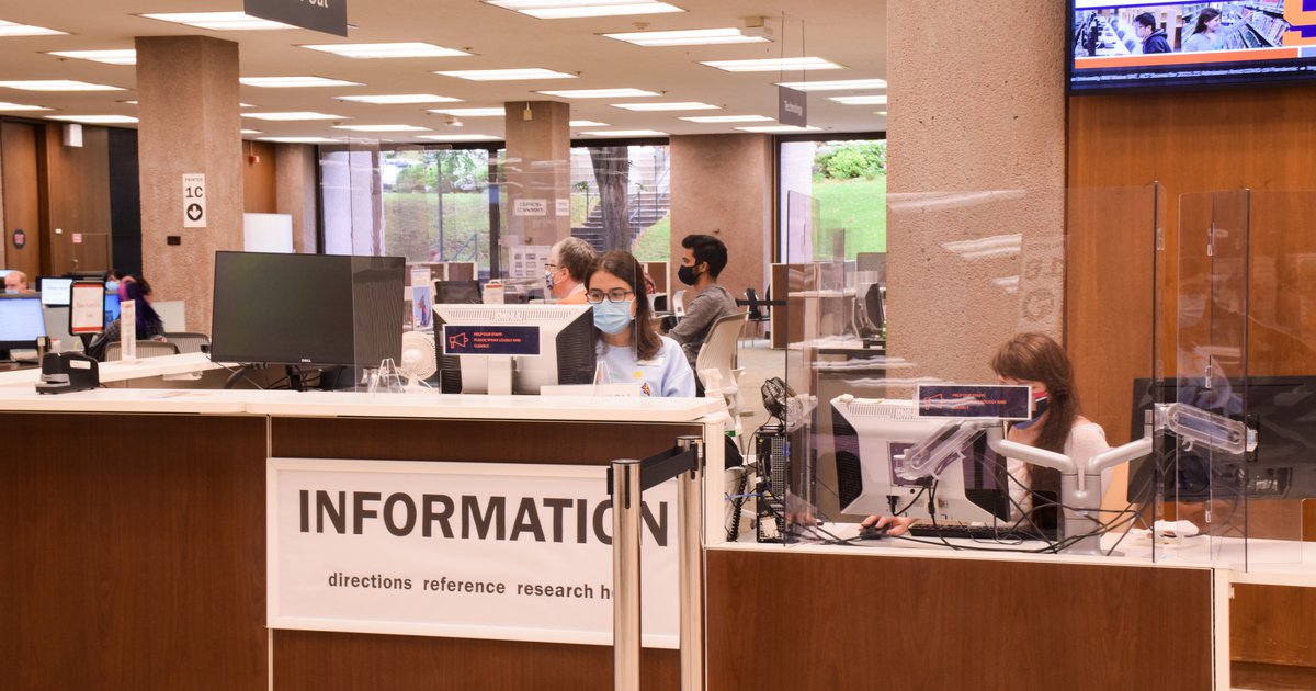 People working behind the information desk in Bird Library