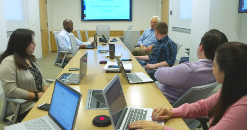 group of law students sitting at table working on laptops