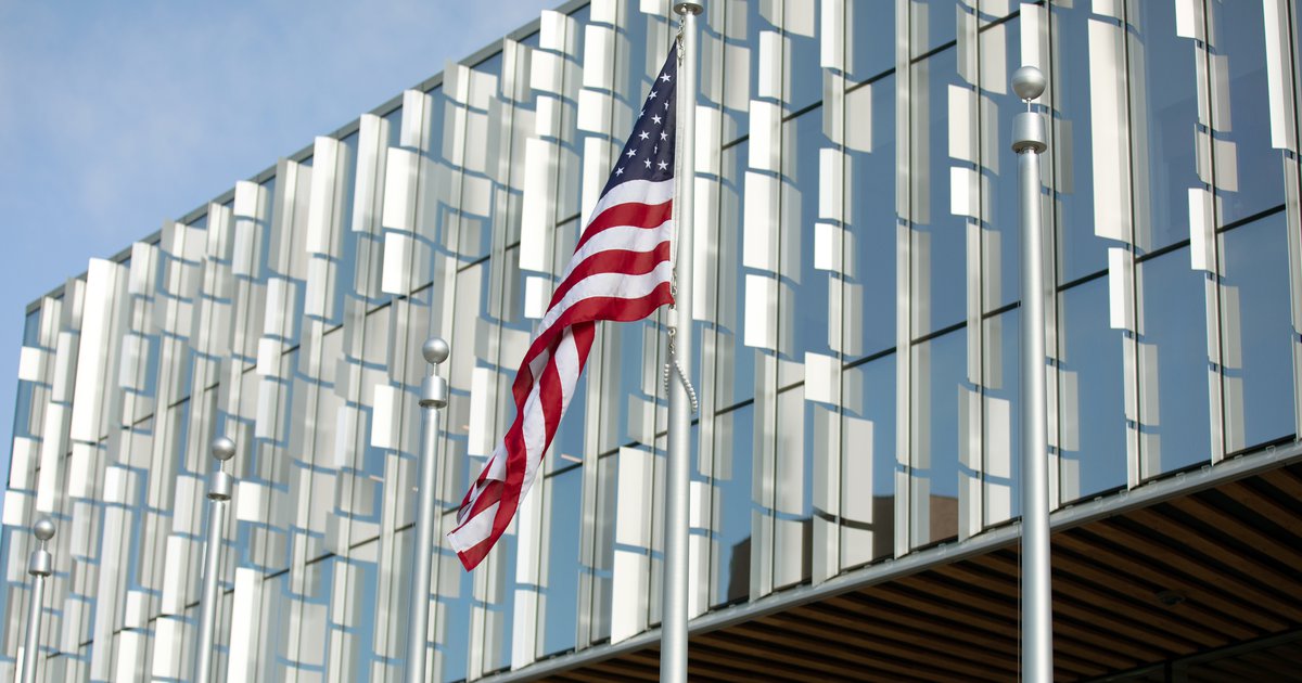 silver mirror building with American flag in foreground