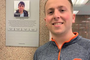 Jack Adler standing next to plaque with Hunter Brooks Watson photo.