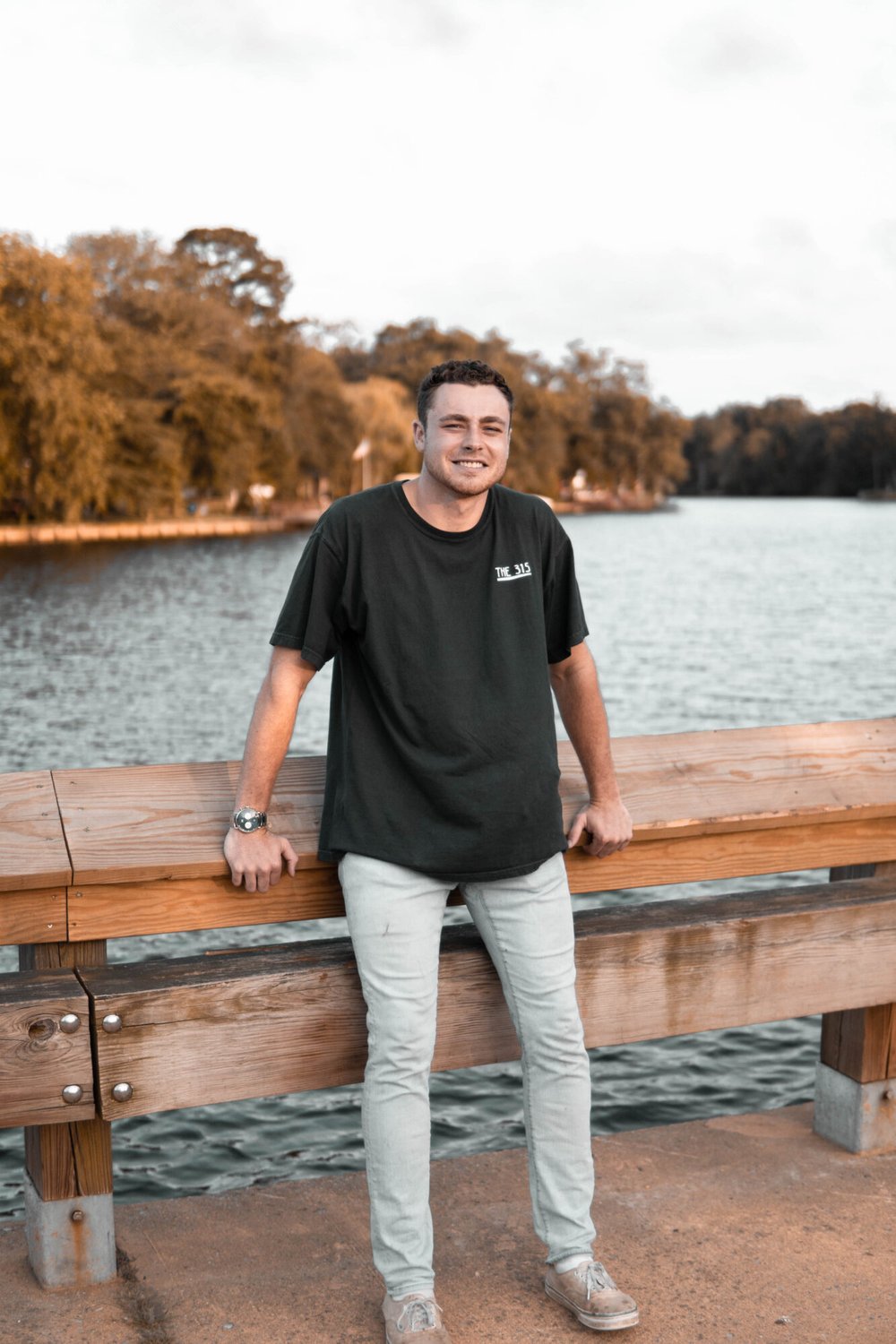 student standing in front of a lake