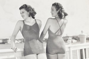Two models standing on a waterfront deck wearing 1930s Jantzen swimsuits