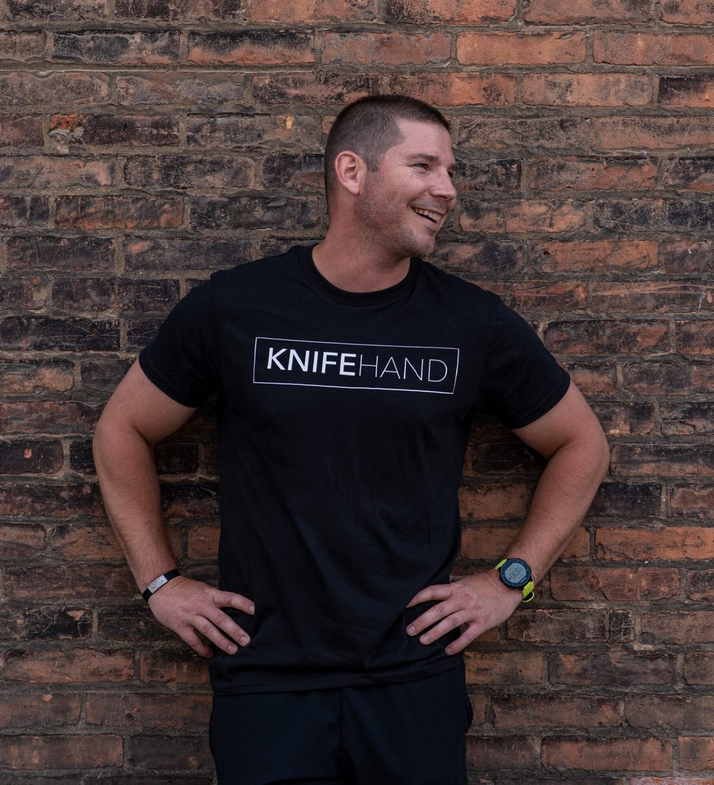 man standing against a brick wall