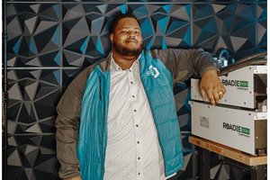 man wearing jacket next to boxed units on table