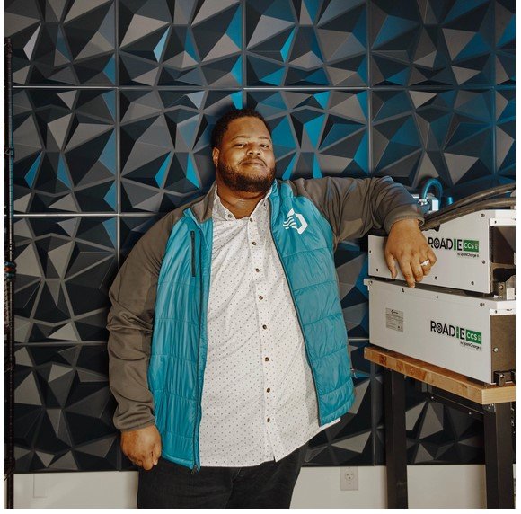 man wearing jacket next to boxed units on table