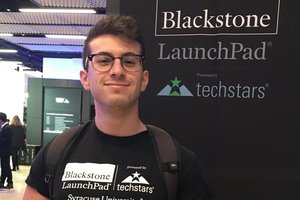person wearing launchpad shirt in front of LaunchPad Techstars banner