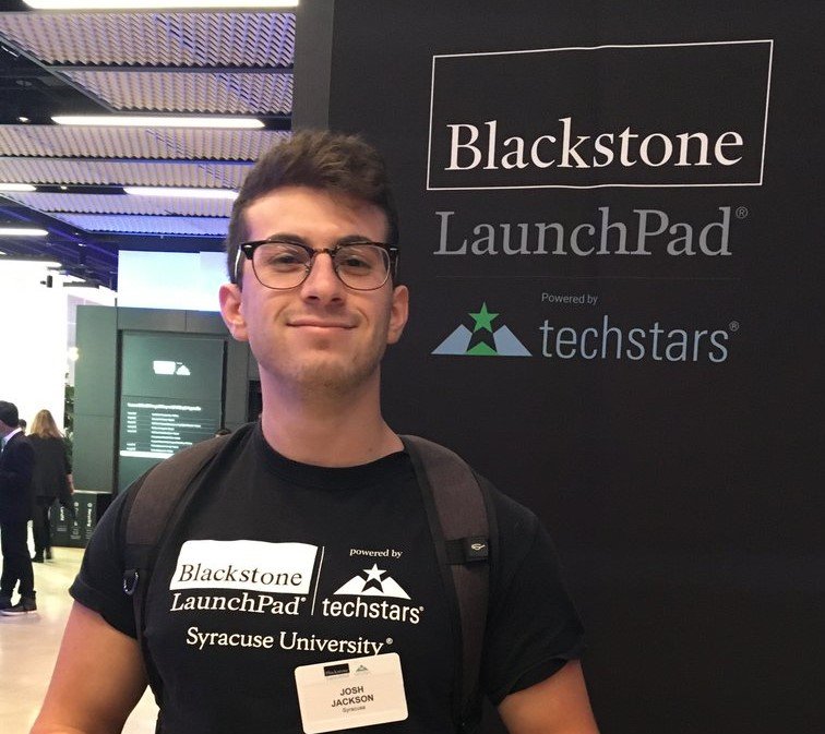 person wearing launchpad shirt in front of LaunchPad Techstars banner