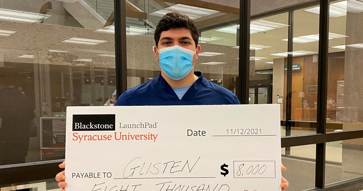 Justin Monaco holds an oversized check