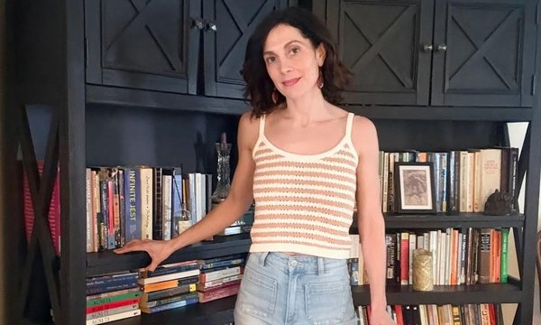 person standing next to bookshelf