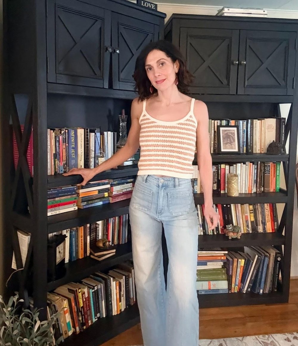 person standing next to bookshelf