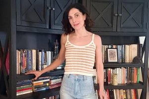 person standing next to bookshelf