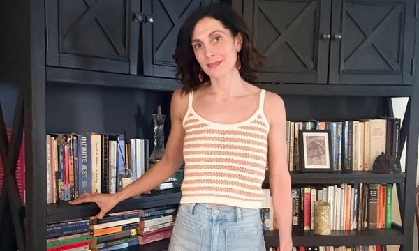 person standing next to bookshelf