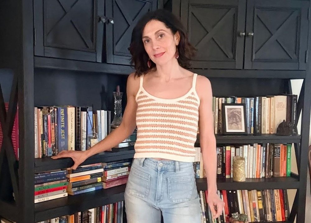 person standing next to bookshelf