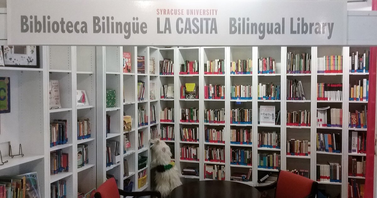 books on shelves with sign that reads Syracuse University Biblioteca Bilinguie La Casita Bilingual Library