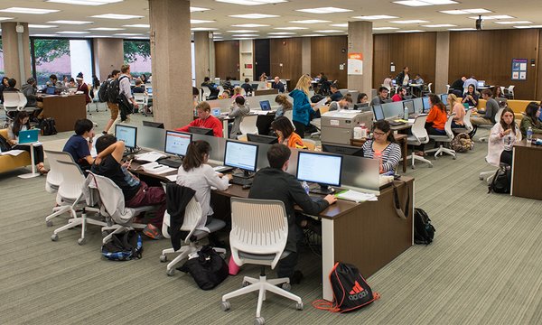 Learning Commons full of students sitting at rows of desktop computers