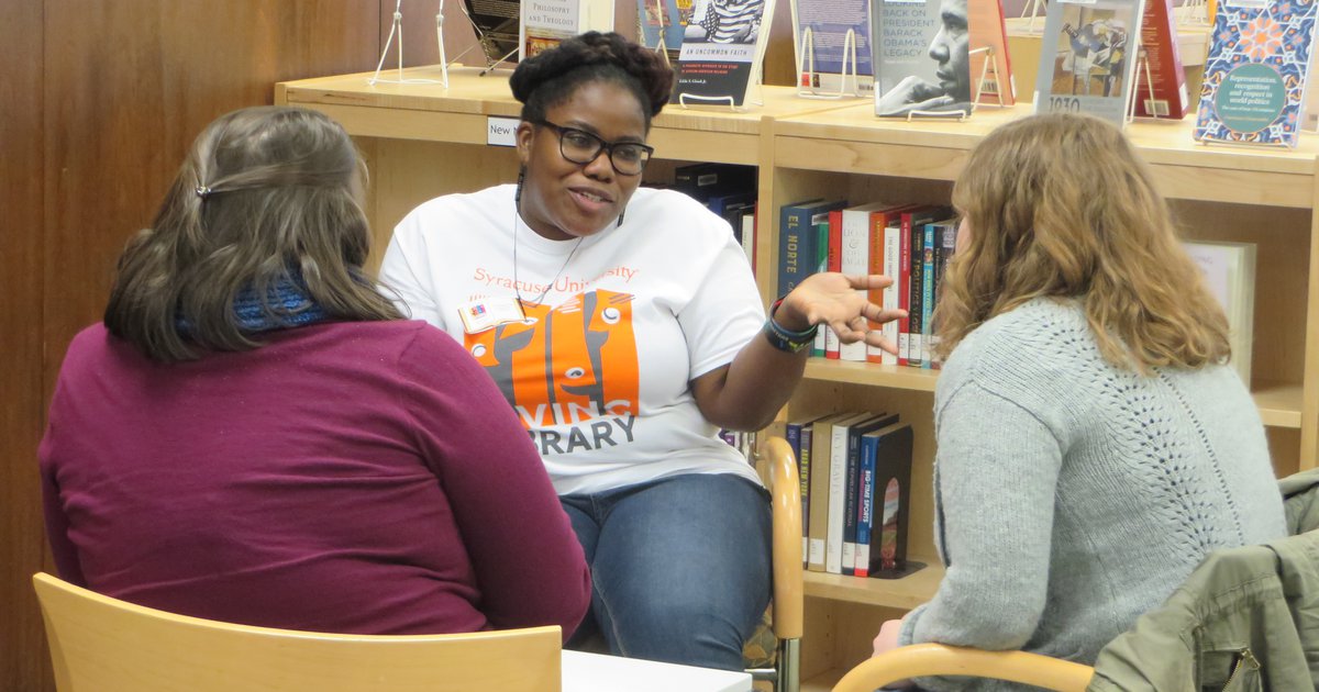 Three people sitting in chairs and talking during Living Library event