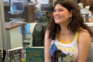 female smiling behind table with jewelry