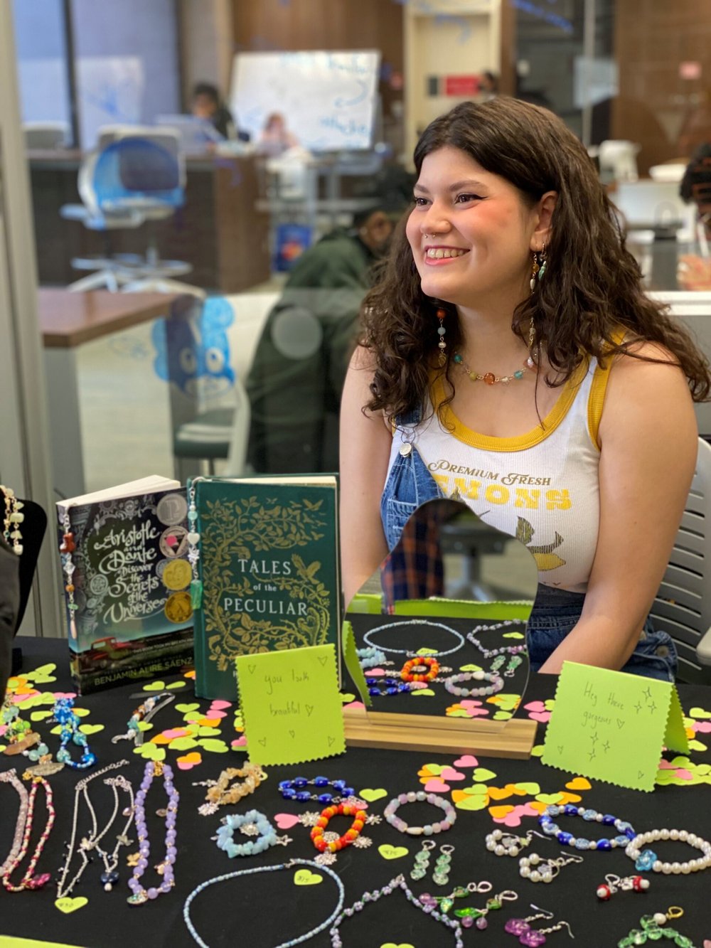 female smiling behind table with jewelry
