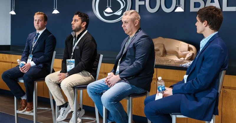 four men in professional attire speak at NIL Agencies Panel
