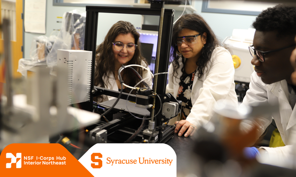 Three researchers observing machinery with NSF I-Corps logo with Syracuse University logo in corner