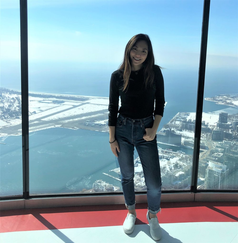 student against a wall of glass overlooking a cityscape