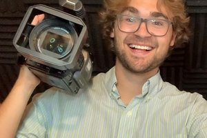 Neil Adams holds a camera over his shoulder