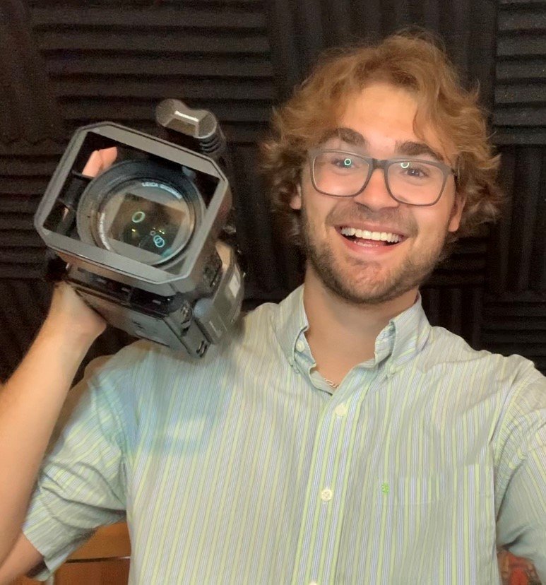 Neil Adams holds a camera over his shoulder