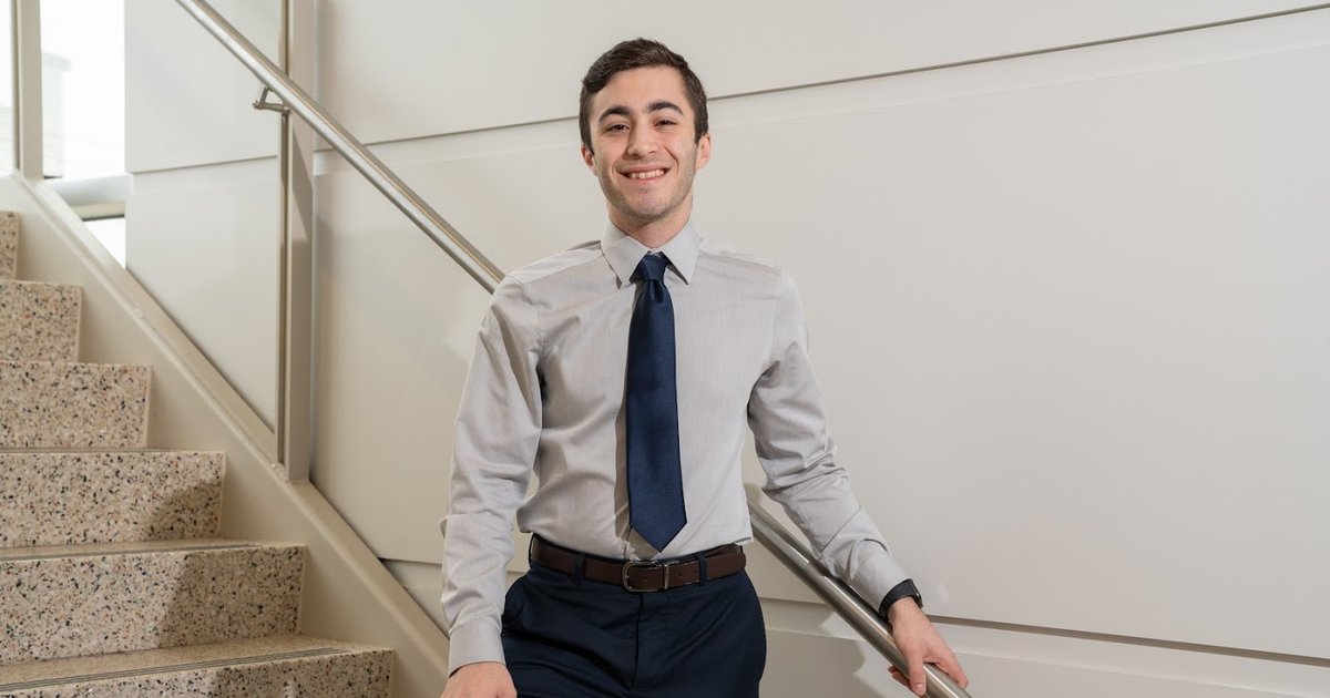 a man standing on the stair, smiling for a photo