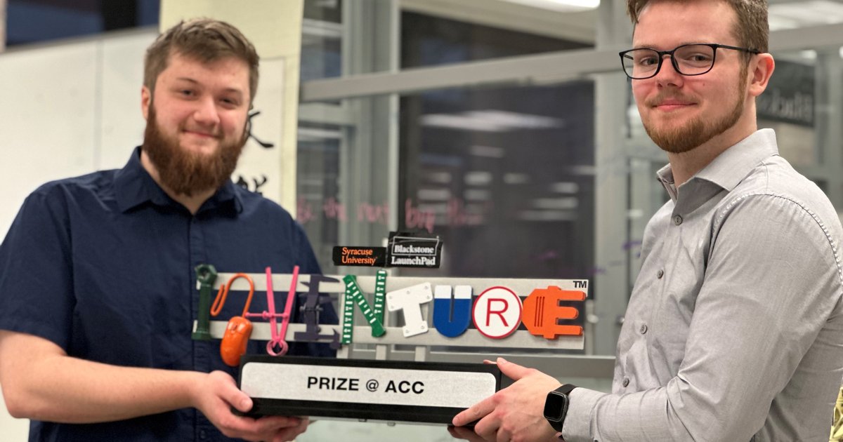 two students holding ACC InVenture prize trophy