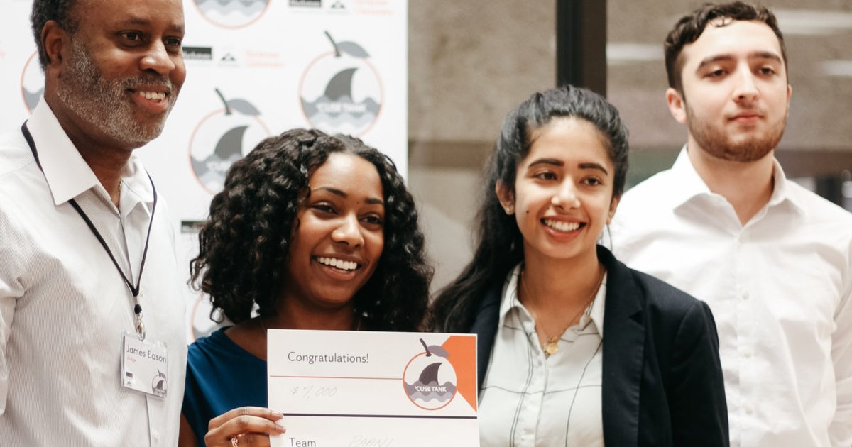 People standing behind a podium holding a check