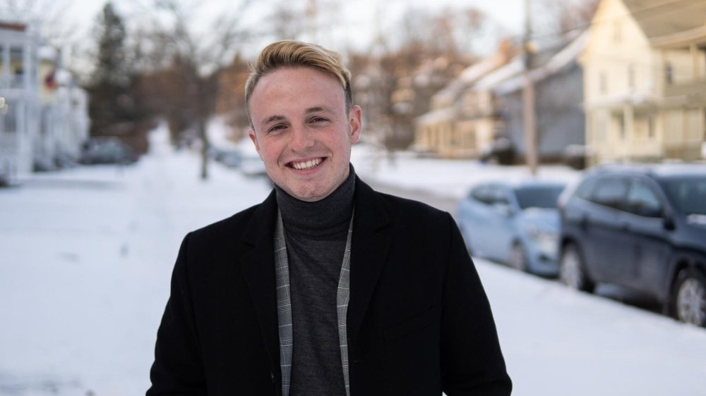 person standing outside with coat on, snow in background