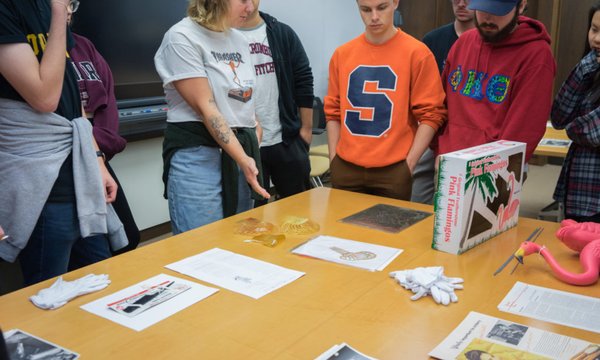 Students gesturing towards plastic objects