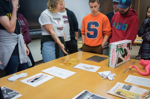 Students gesturing towards plastic objects