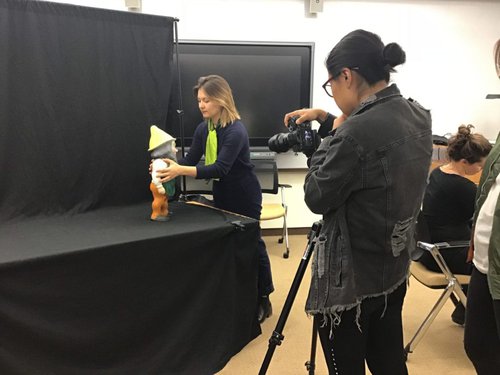 Plastics curator helping student photograph plastic object