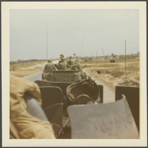 Polaroid photograph of servicemen riding in a military vehicle. E. Thomas Billard Papers