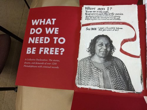 White text on a red background. reads "What do we need to be free?" and has picture of Black woman below text